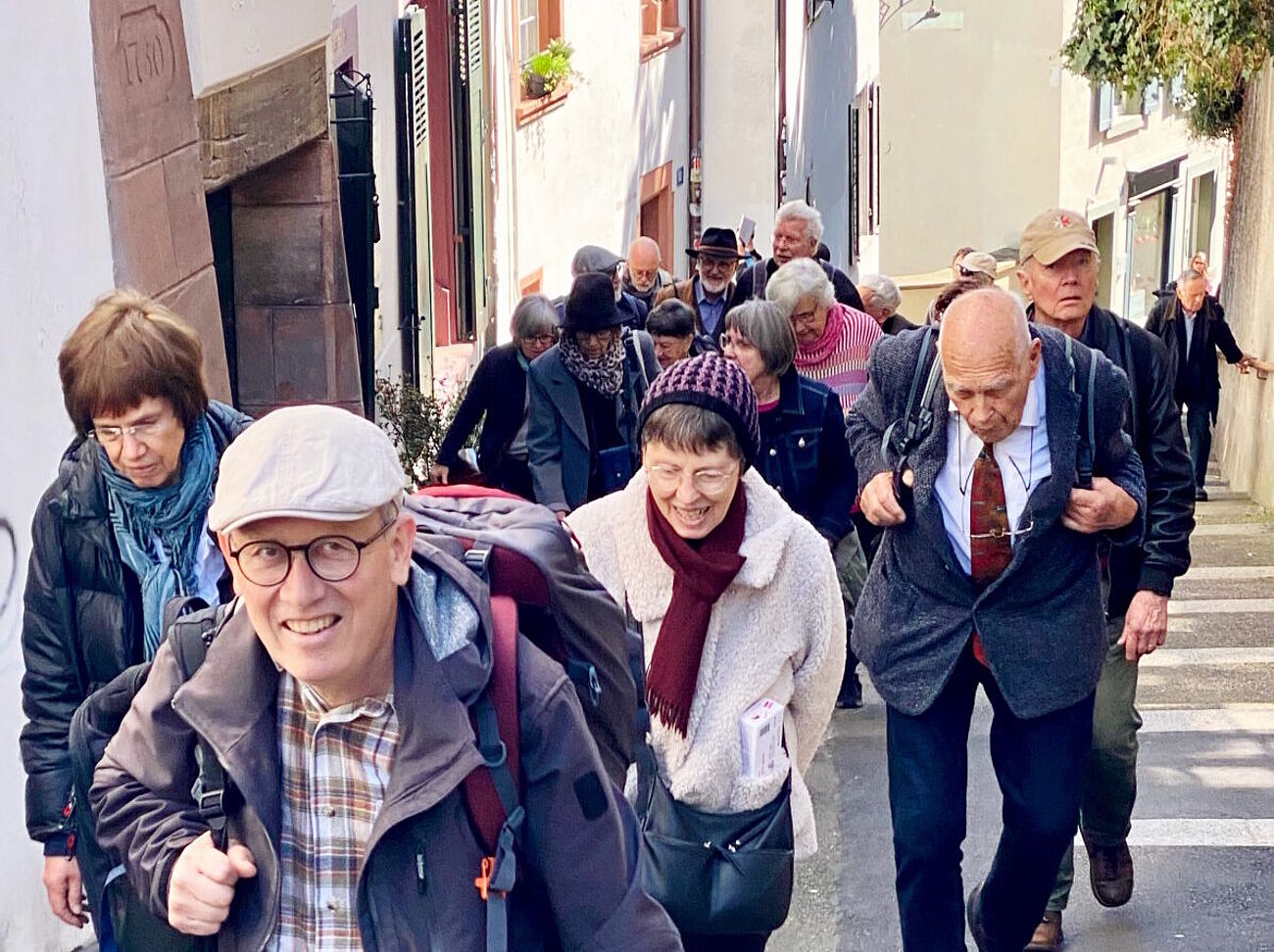 Teilnehmende beim Stadtrundgang durch Basel auf einer steil nach oben führenden Straße