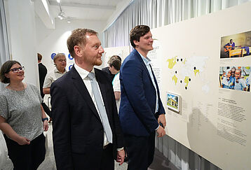 Michael Kretschmer und Conrad Clemens betrachten eine Ausstellungstafel