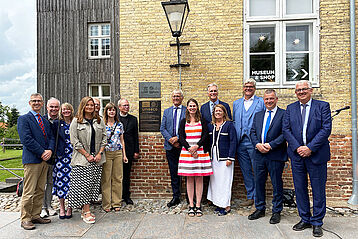 Gruppenbild vor Haus mit UNESCO-Plakette