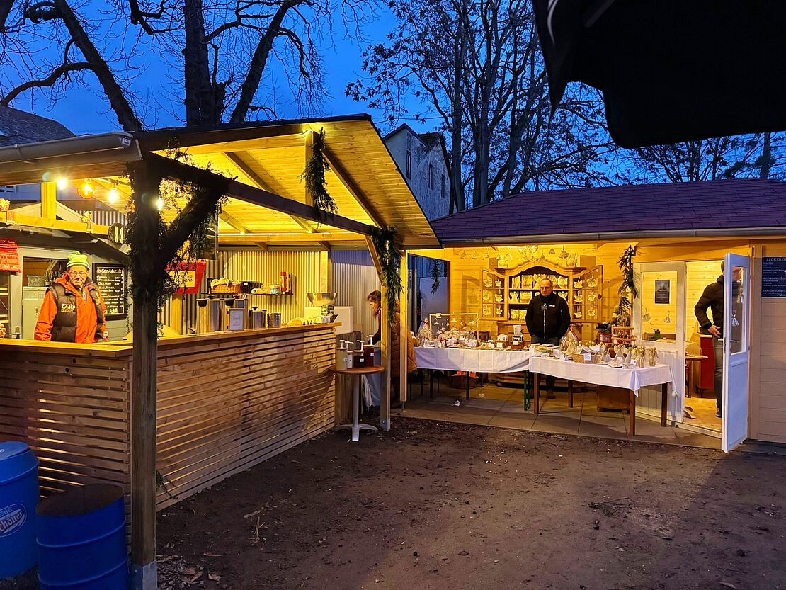 Zwei beleuchtete Hütten am Abend.