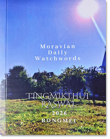 Cover der Losung in Rongmei-Sprache; abgebildet ist eine Wiese mit Kirche im HIntergrund