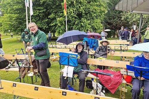 Bruder Salewski mit Regenschirm im Park sitzend