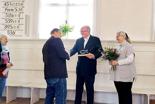 Ein Mitglied des Ältestenrats bedankt sich per Handschlag für die Zusammenarbeit
