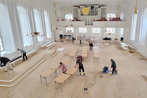 Einige Tische im vorher leergeräumten Saal