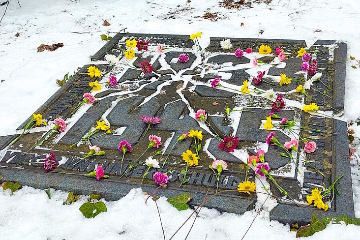 Ansicht des Gedenksteins mit zuvor dort abgelegten Blumen