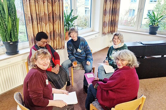 kleine Gruppe von Menschen im Kreis sitzend, die sich über verschiedene Themen austauschen