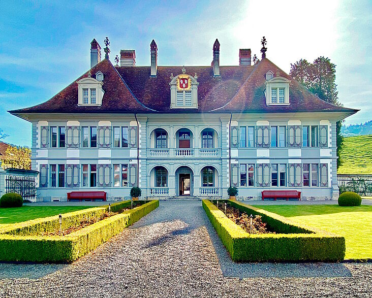 Fassade des Schlosses in Oberdiessbach (früher im Besitz der Familie von Wattewyl); im Vordergrund ein mit niedrigen Buchsbaumhecken gesäumter Weg, der gradlinig auf das Schloss zuläuft