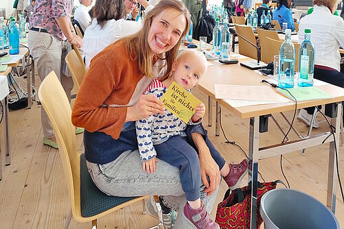 Mutter mit Schoßkind am Arbeitstisch
