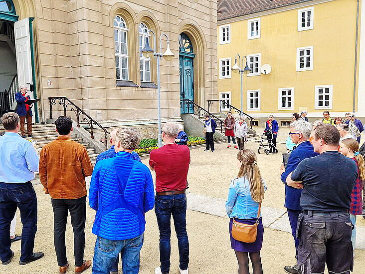 Kreis von Menschen, welche sich zum 150-jährigen Jubiläum vor dem Saal versammelt haben.