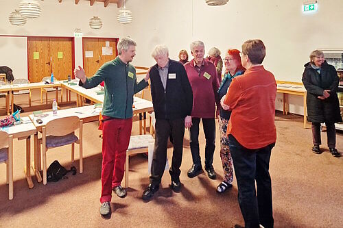 Christian Flöter mit einer kleinen Gruppe von Teilnehmern während der Pause ins Gespräch vertieft.
