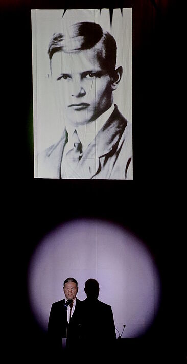 Ein Bild von Bonhoeffer aus Kindheitstagen, darunter der Sprecher, welcher die Texte zwischen den Liedern spricht.