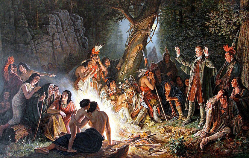 Gemälde von Alfred Bernert nach dem Original von Christian Schussele; zu sehen ist David Zeisberger, wie er vor Indianern am Lagerfeuer steht und predigt