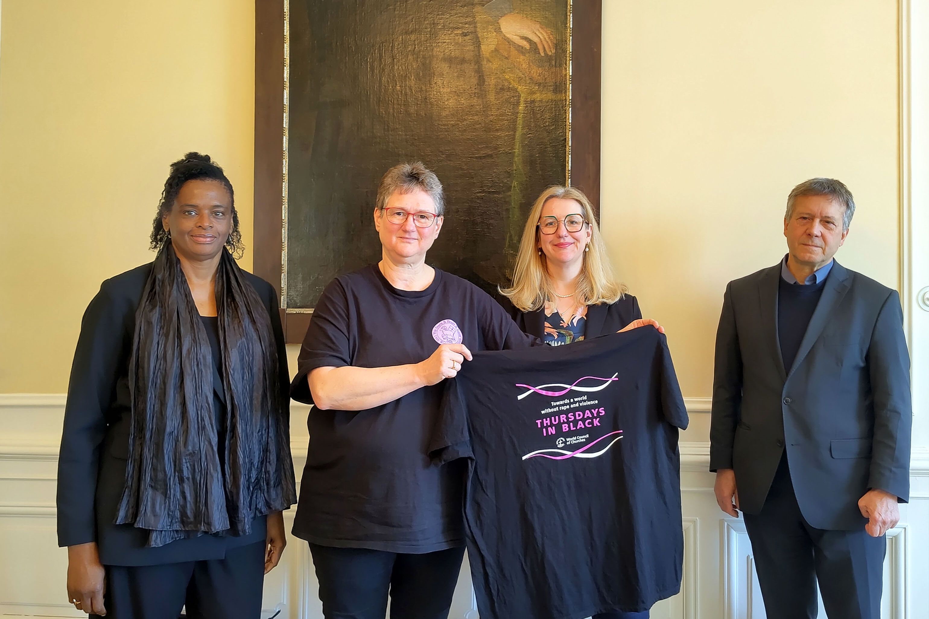 Vier schwarzgekleidete Personen vor einem Porträt von Johann Amos Comenius