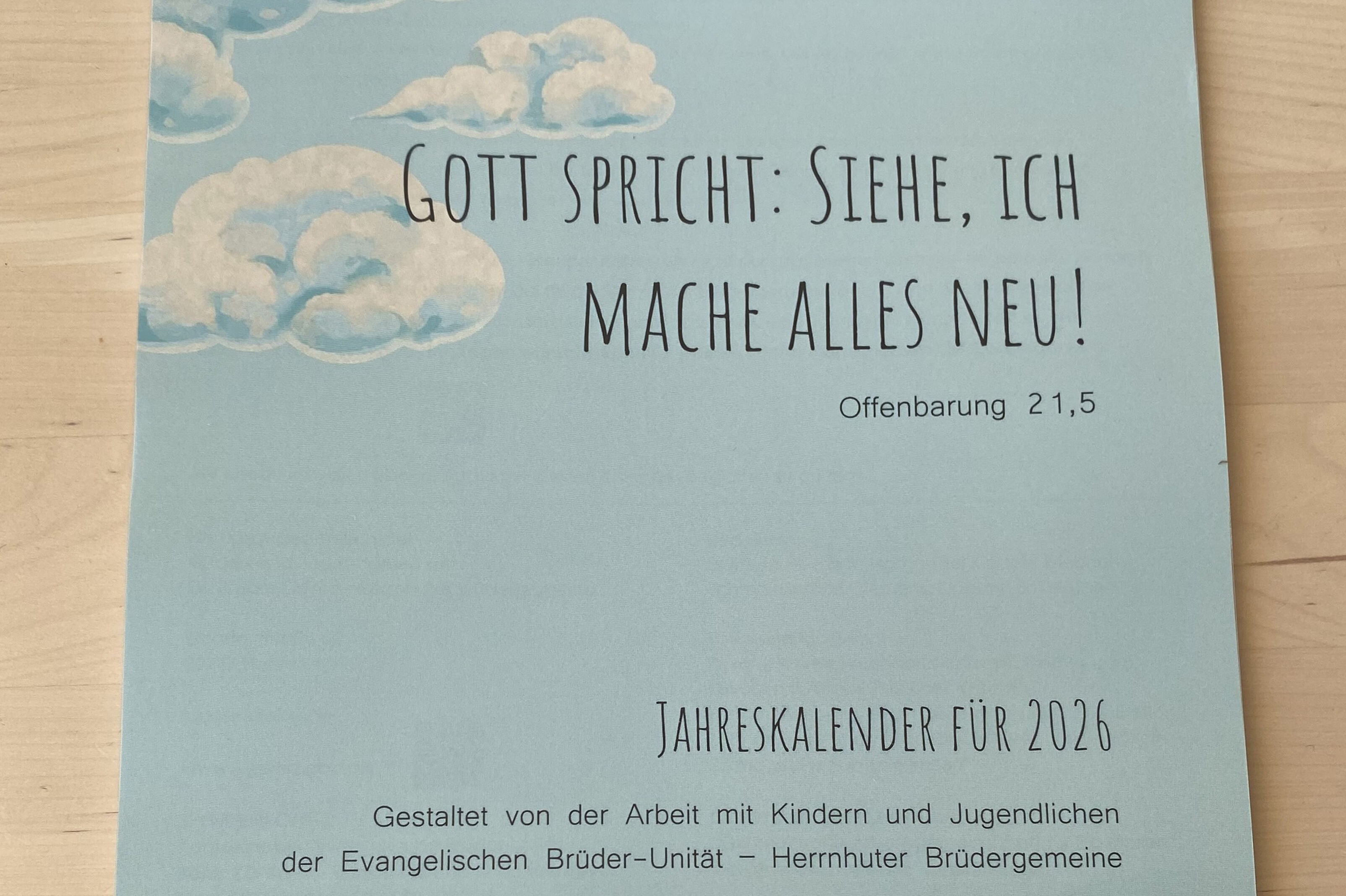 Titelbild mit der Jahreslosung, einzelne Wolken auf hellblauem Hintergrund