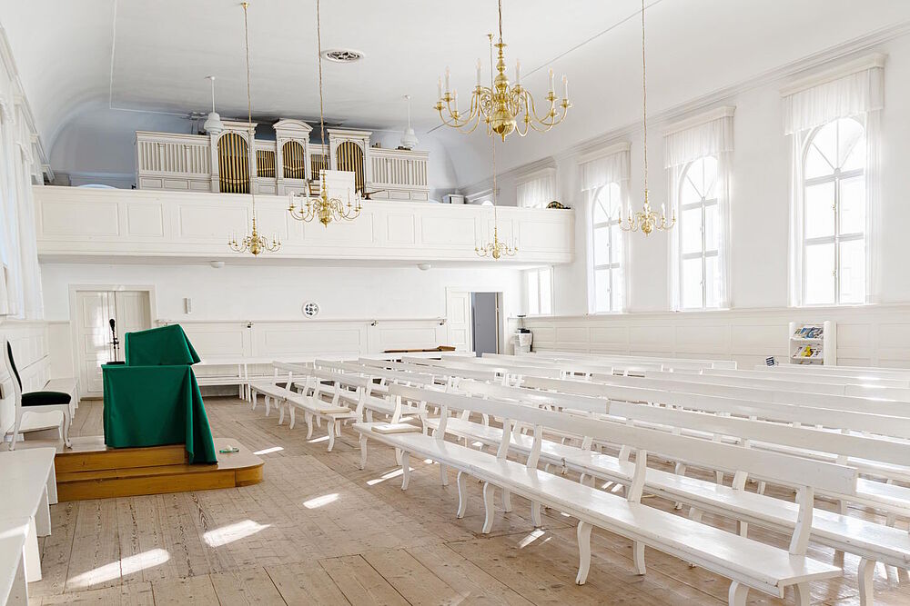 Innenraum des Kirchensaales in Kleinwelka mit Blick auf Liturgustisch und Orgel auf der Empore (Foto von Sophia Korzen)