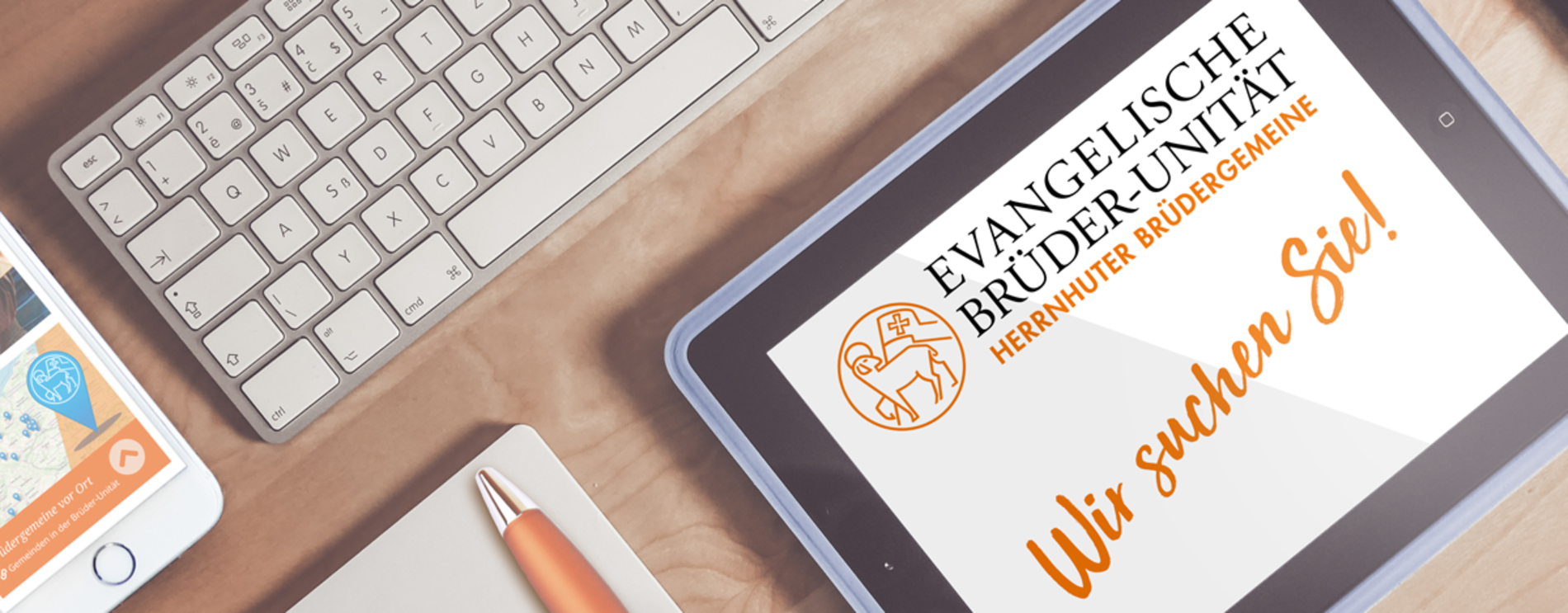 Aufsicht auf einen Schreibtisch mit Tablet; zu lesen ist "Wir suchen Sie"