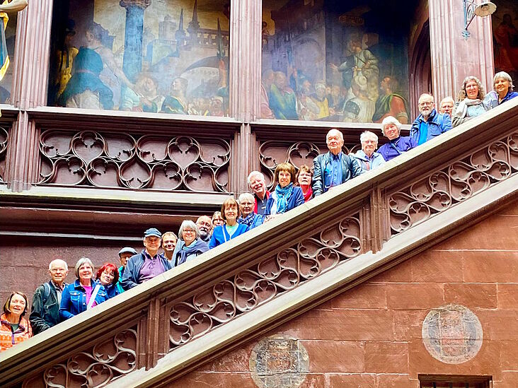 Gruppenbild der Teilnehmer und Teilnehmerinnen, welche auf einer großen Steintreppe verteilt stehen und über die Brüstung schauen