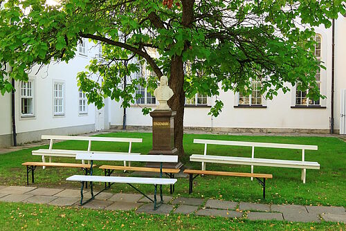 Leere Bänke im Kirchengarten