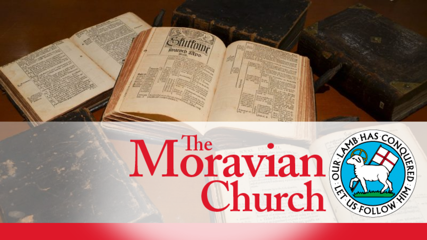 Verlinkung zur Seite der Moravian Church in Amerika mit Informationen zur Geschichte; zu sehen sind alte aufgeschlagene Bücher und das Logo der Moravian Church