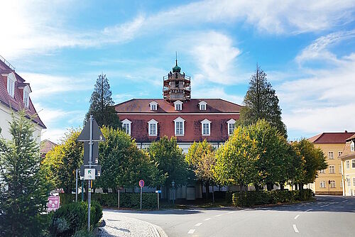 Blick auf den Kirchensaal Herrnhut. Auf dem eingerüsteten Kirchturm stehen vier Personen.