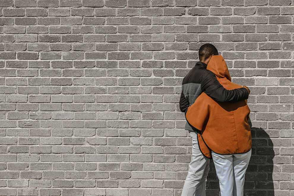 zwei Menschen vor einer Mauer