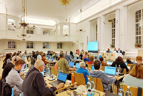 Blick auf eine große Zahl an Menschen mit offenen Laptops
