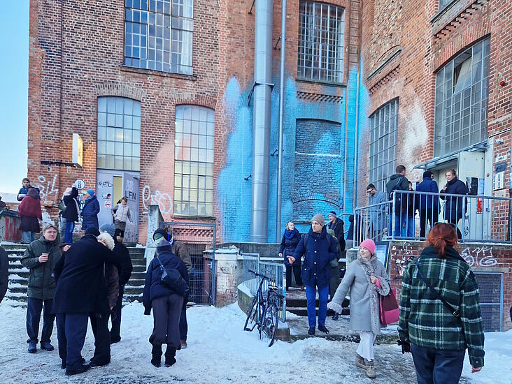 Besucher der Alten Spinnerei vor dem historischen Gebäude zum Winterrundgang versammelt