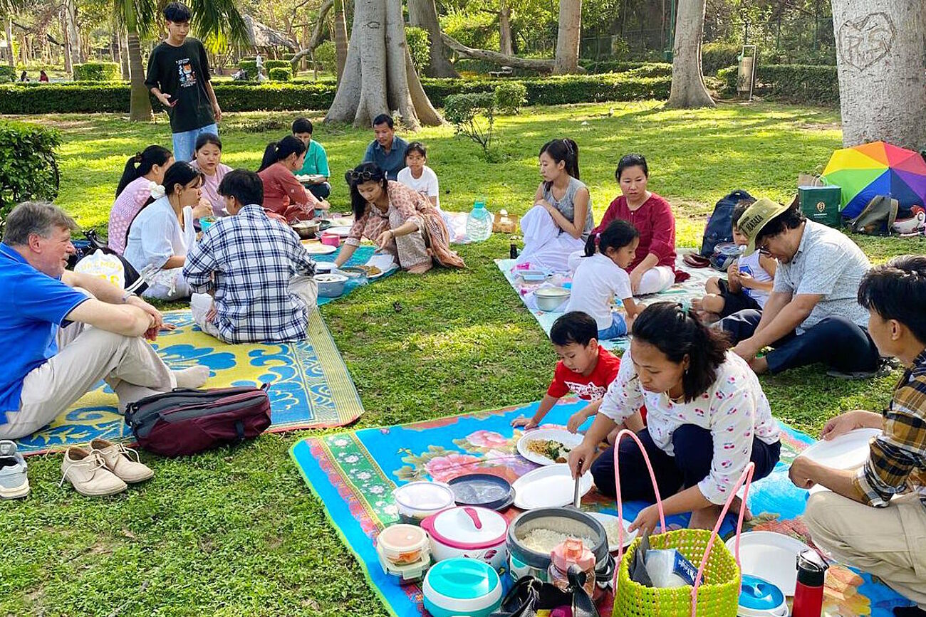 Picknick – auf Decken sitzende Menschen auf einer Wiese