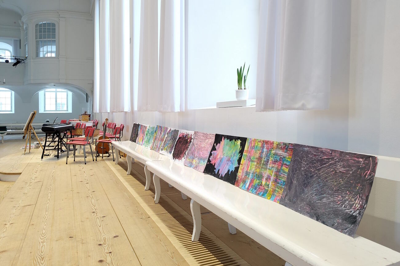 Im Kirchensaal auf einer Bank aufgestellte künstlerische Arbeiten der Schülerinnen und Schüler.