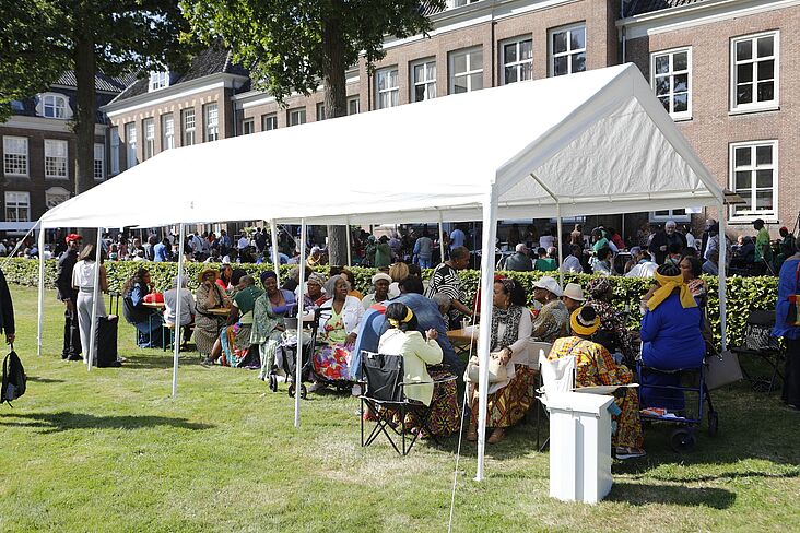 Menschen im Pavillion auf der Wiese vorm Kirchensaal in Zeist