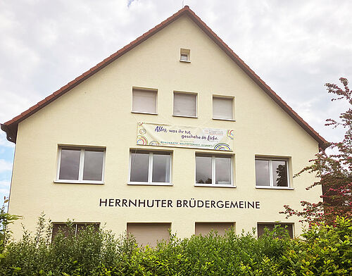 Banner mit Aufschrift "Alles was ihr tut, geschehe in Liebe" am Unitätshaus in Bad Boll