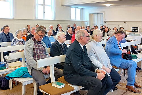 Geschwister Weigel sitzen in der ersten Bankreihe, dahinter sitzt die Gemeinde