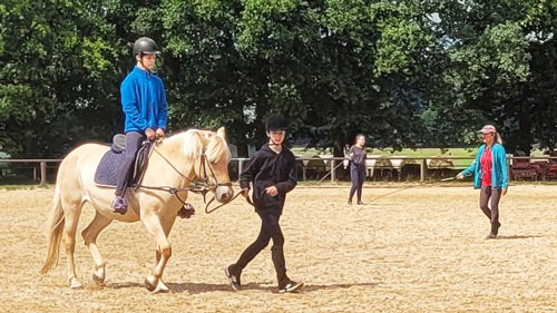 Kind auf Pferd reitend durch Felder